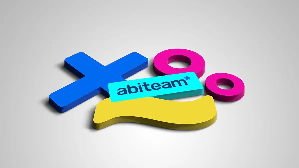 Dreidimensionale Darstellung des abiteam*-Logos mit den Markenelementen X, O und geschwungener Form in Blau, Pink und Gelb auf hellgrauem Hintergrund.