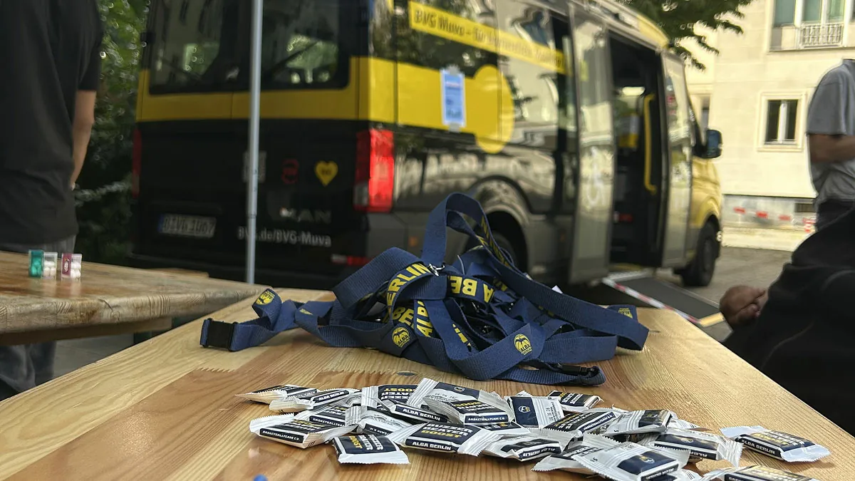 Detailaufnahme eines Tisches im BVG Muva mit ausliegenden Informationsflyern und Bändchen. Das Setting zeigt die Event-Vorbereitung und unsere organisierte Kommunikation für barrierefreie Mobilität in Berlin.